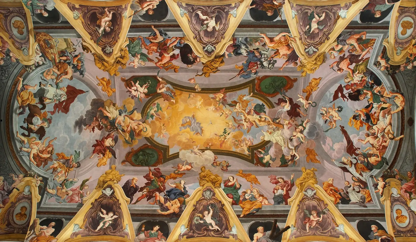 An ornate cathedral ceiling filled with painted figures and golden decoration